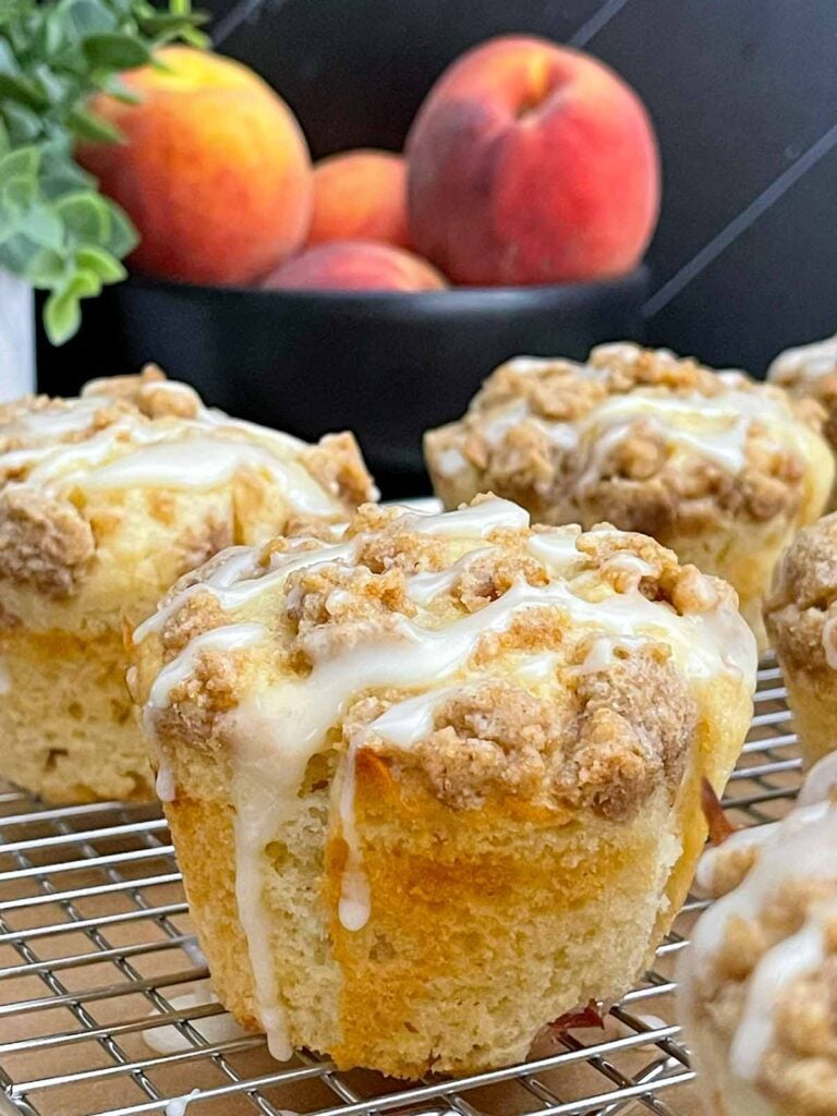 Peach glaze drizzled over warm easy homemade peach muffins.