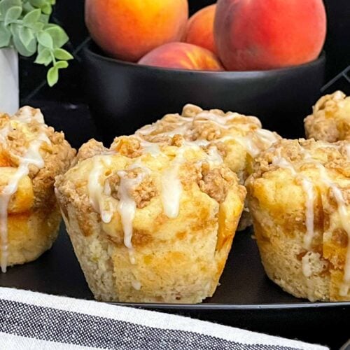 Soft and fluffy peach muffins made with fresh peaches, peach preserves, cinnamon streusel, and peach glaze.