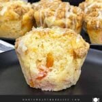 Peach muffin split open to show the soft crumb and juicy peach pieces inside.