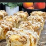 Fresh peach muffins cooling on a wire rack after baking.
