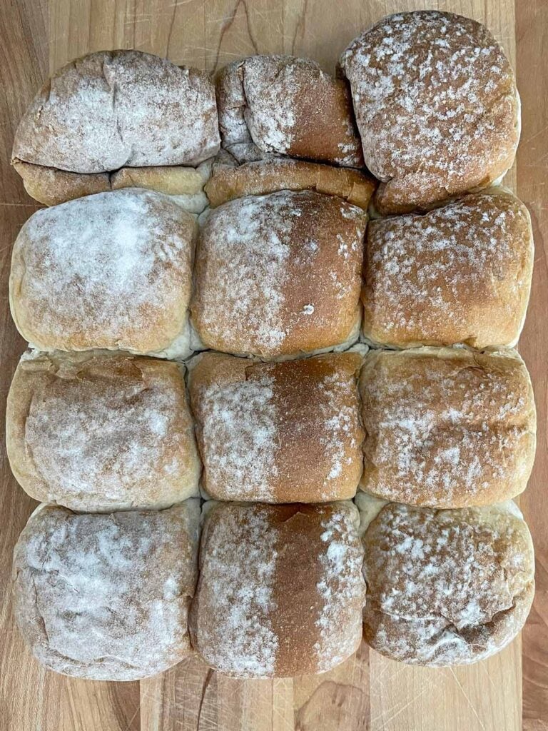 Savory Hawaiian slider rolls on a cutting board before slicing.