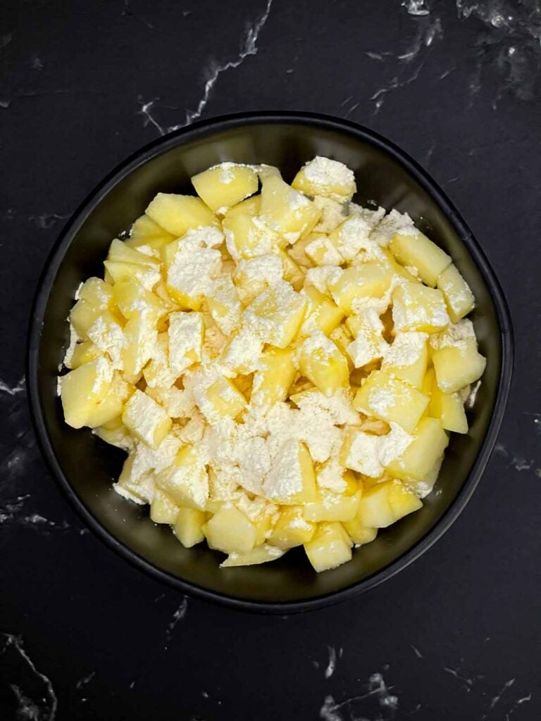 Diced apples coated with flour for apple cinnamon muffins.