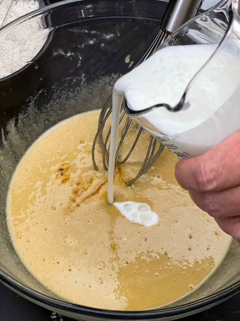 Buttermilk and vanilla extract being added to the wet ingredients.