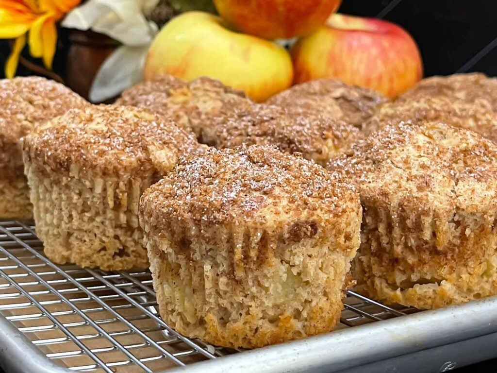 Apple cinnamon muffins with golden domed tops and a crunchy cinnamon sugar topping.