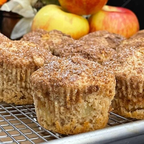 Apple cinnamon muffins with golden domed tops and a crunchy cinnamon sugar topping.