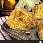 Freshly baked apple cinnamon muffins with tall golden tops in a muffin pan.