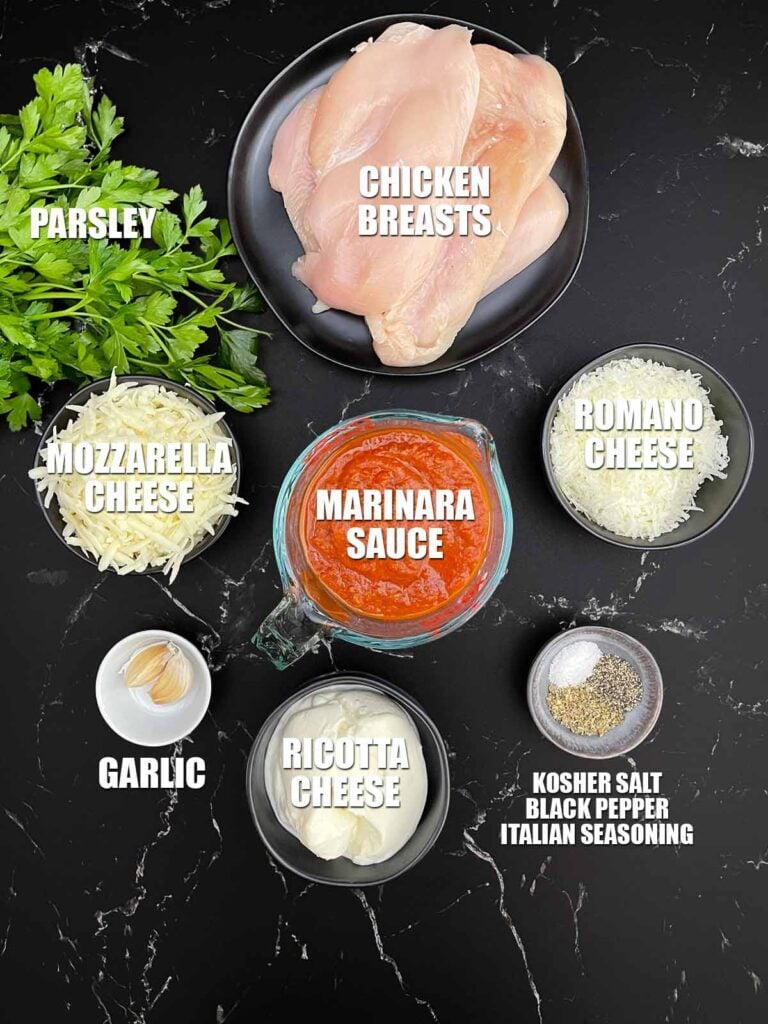 Ingredients for baked ricotta chicken including chicken breasts, ricotta, Pecorino Romano, mozzarella, marinara sauce, garlic, and seasonings.