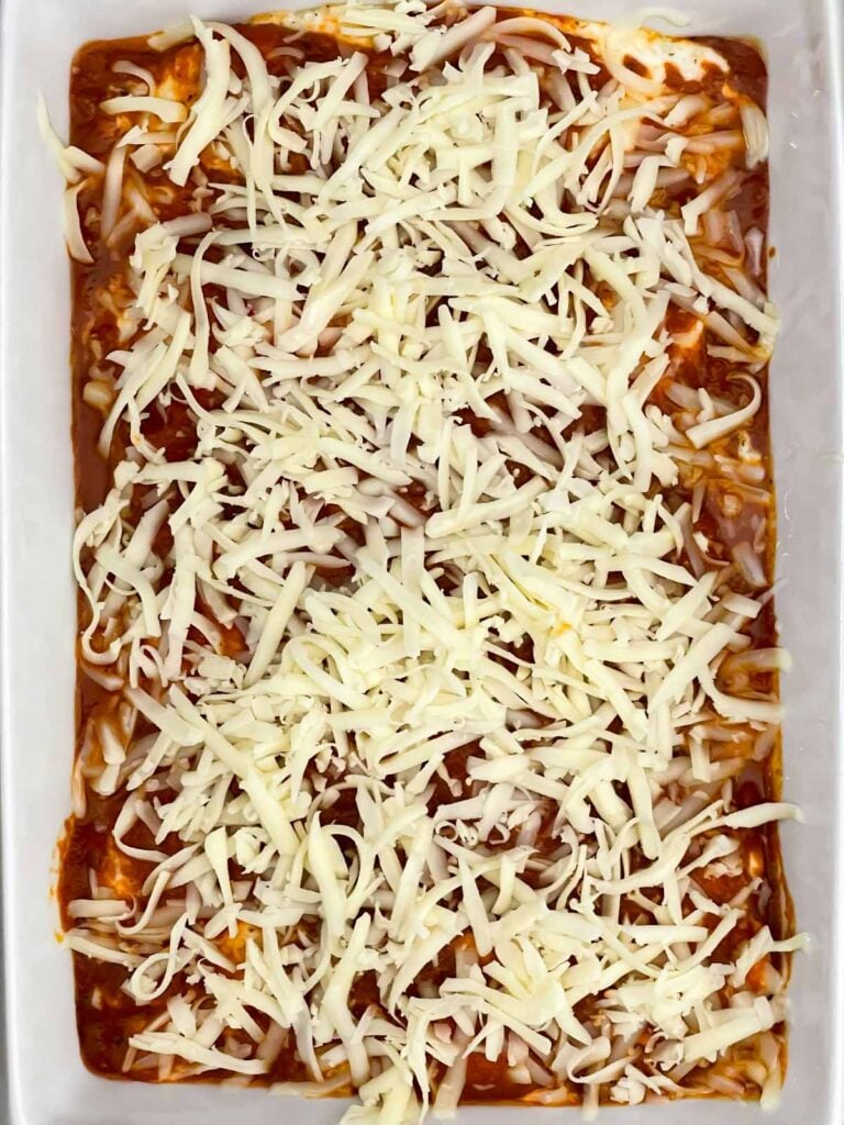 Partially baked ricotta chicken topped with shredded mozzarella cheese.