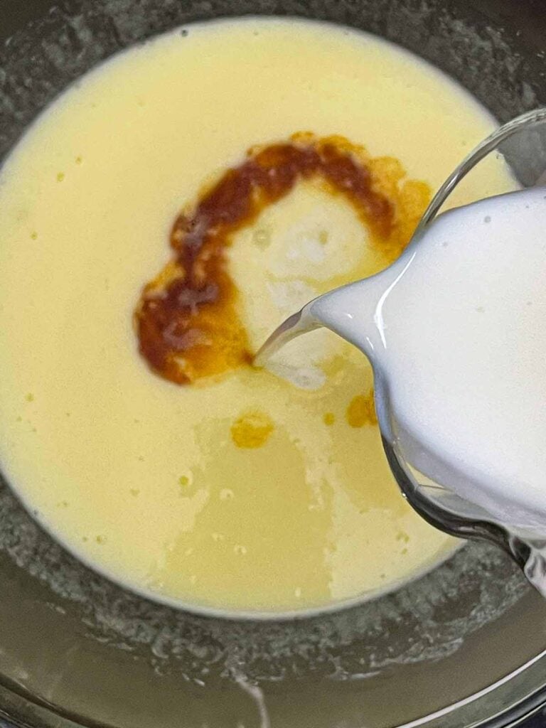 Vanilla and buttermilk being whisked into the egg mixture.