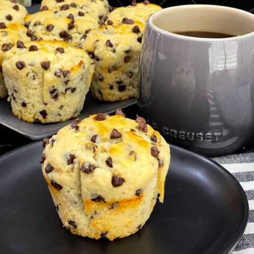 Single bakery style chocolate chip muffin with a golden domed top.
