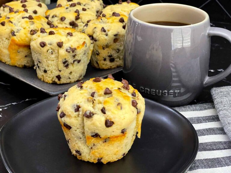 Single bakery style chocolate chip muffin with a golden domed top.