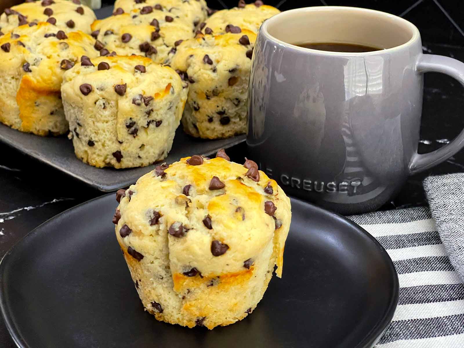 Single bakery style chocolate chip muffin with a golden domed top.