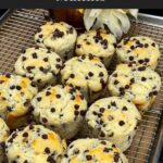 Chocolate chip muffins on a wire rack with a golden domed top.
