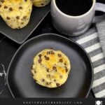 Single bakery style chocolate chip muffin served with a cup of coffee.