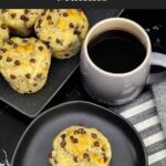 Single bakery style chocolate chip muffin served with a cup of coffee.