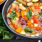 Finished minestrone soup with tender vegetables, beans, spinach, and tomato broth in the slow cooker.