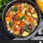Slow cooker minestrone soup with vegetables, beans, spinach, and ditalini pasta in tomato broth.