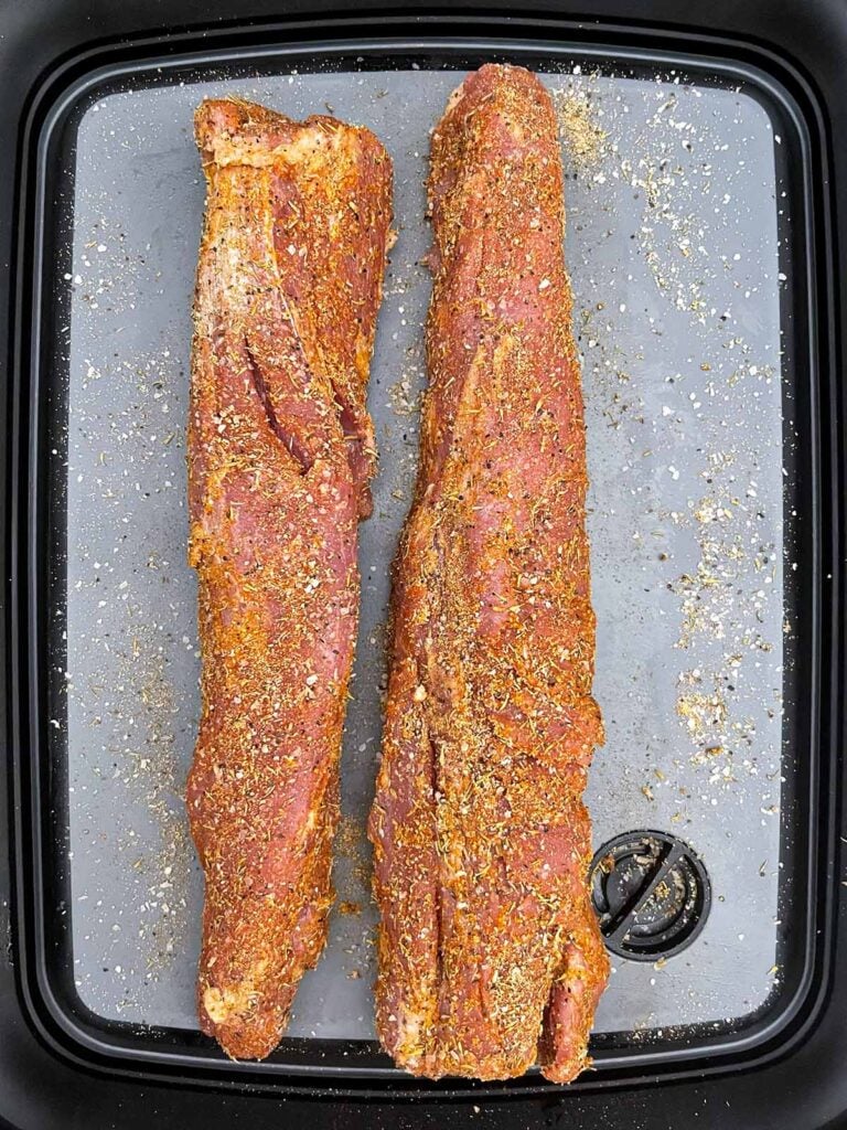 Seasoned pork tenderloins ready to be seared.