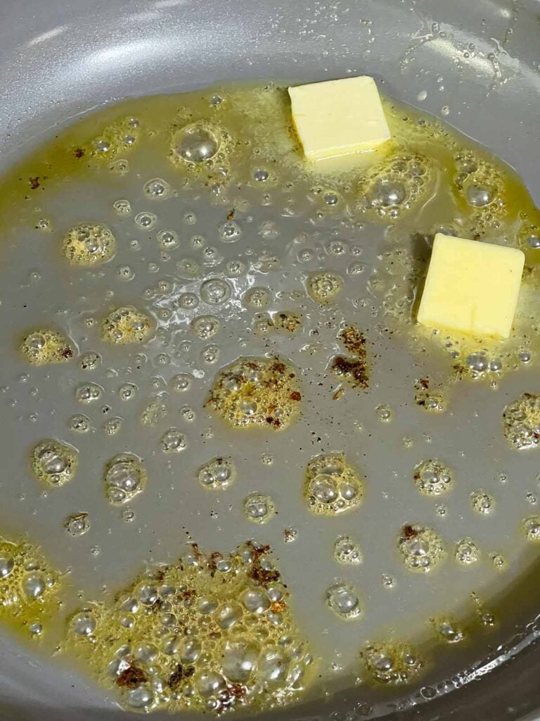 Butter melting into the browned bits left in the skillet after cooking pork.