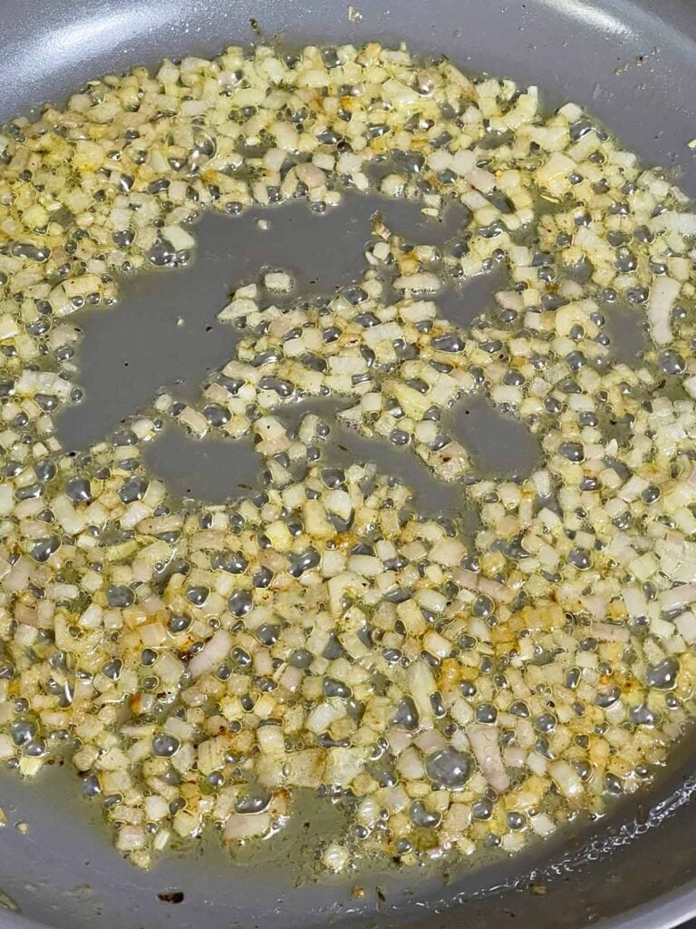 Shallots cooking in butter to begin the Dijon cream sauce.