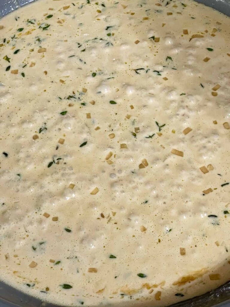 Creamy Dijon sauce gently simmering in the skillet.