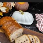 Sliced cranberry walnut bread on a cutting board showing the cranberries and walnuts throughout the loaf.