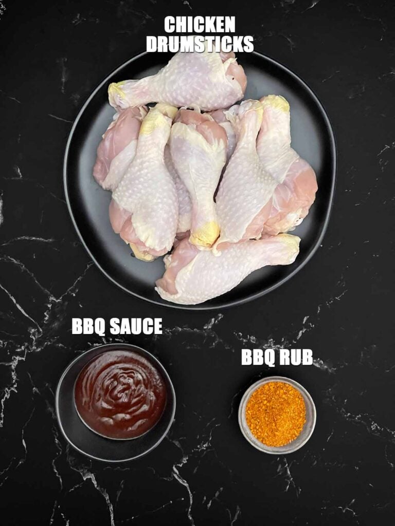 Chicken drumsticks, BBQ dry rub, and BBQ sauce for smoked chicken lollipops.