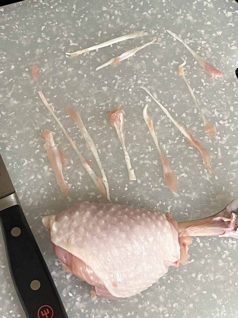 Raw chicken drumstick trimmed and shaped into chicken lollipops.