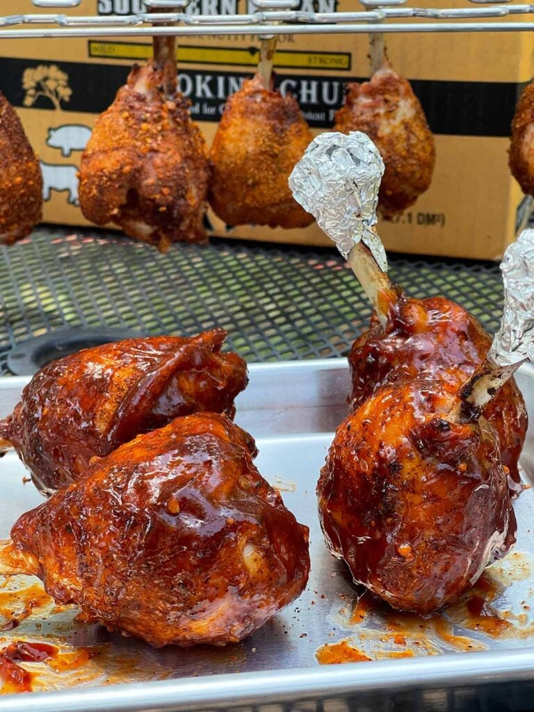 Smoked chicken lollipops coated with BBQ sauce before being returned to the smoker.