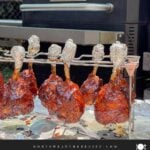 Finished smoked chicken lollipops hanging on the rack after being removed from the smoker.