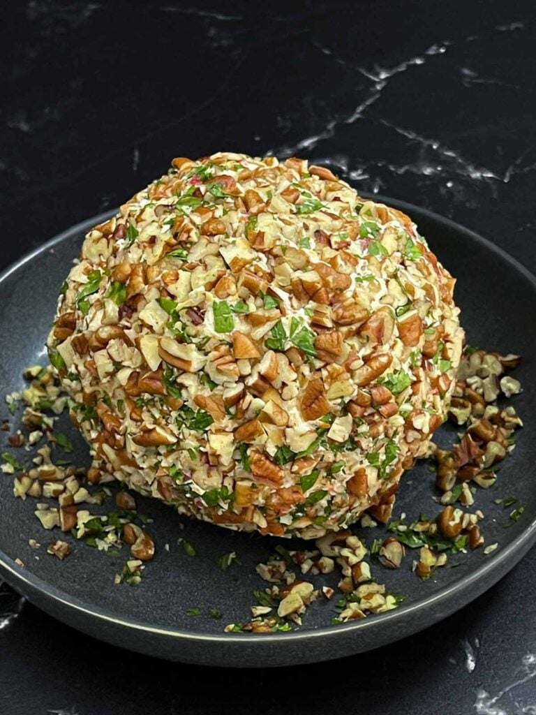 Chilled Pimento Cheese Ball completely coated with chopped pecans and ready to serve.