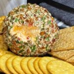 Creamy Pimento Cheese Ball with sharp cheddar and pimentos served with crackers.