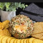 Pimento Cheese Ball coated in chopped pecans and served with crackers.