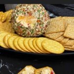 Creamy Pimento Cheese Ball with sharp cheddar and pimentos served with crackers.