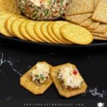 Creamy Pimento Cheese Ball with sharp cheddar and pimentos served with crackers.