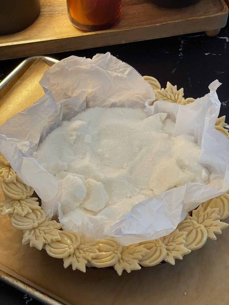 Pie crust lined with parchment paper and filled with pie weights for par-baking.