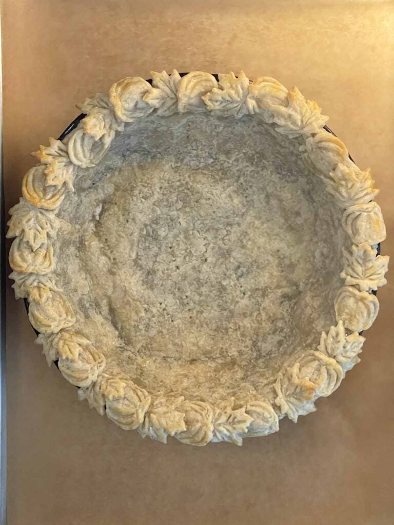Partially baked pie crust with lightly golden edges.