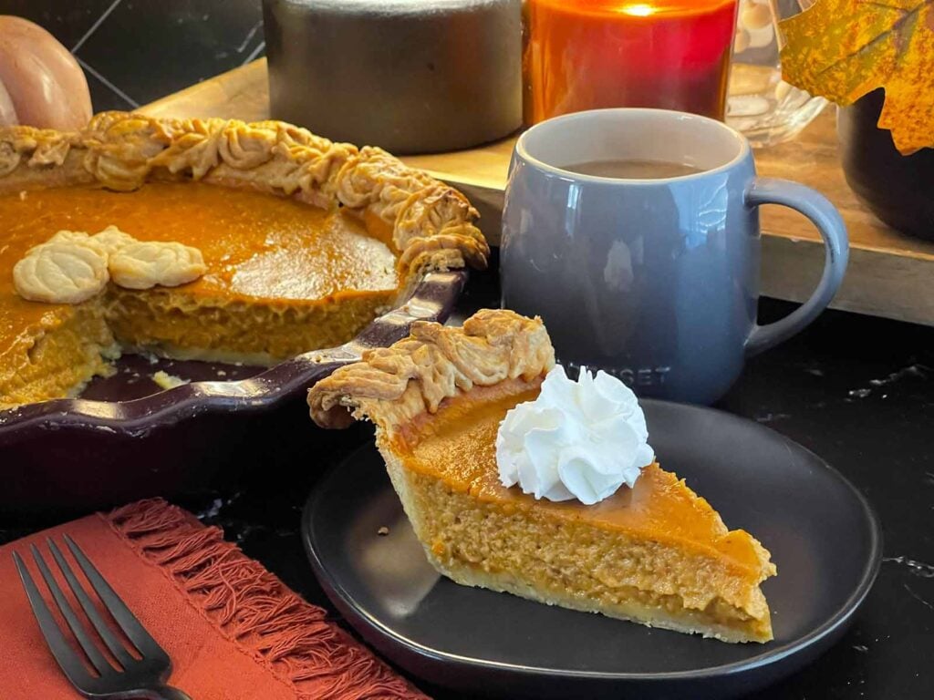 Homemade eggnog pumpkin pie in a flaky pie crust with decorative pastry edges.