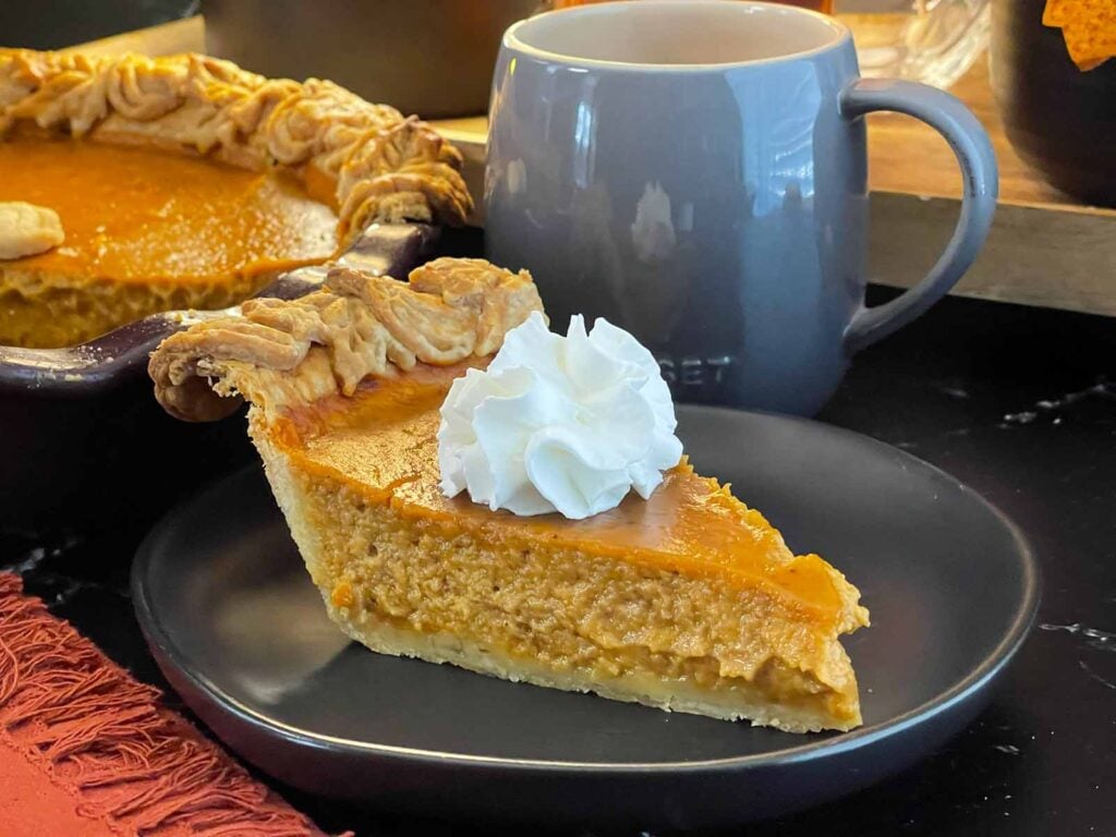 Homemade eggnog pumpkin pie in a flaky pie crust with decorative pastry edges.