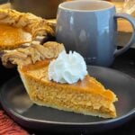 Homemade eggnog pumpkin pie in a flaky pie crust with decorative pastry edges.