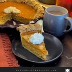 Slice of eggnog pumpkin pie topped with whipped cream.