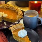 Slice of creamy eggnog pumpkin pie showing the smooth pumpkin filling and flaky crust.