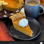 Slice of creamy eggnog pumpkin pie showing the smooth pumpkin filling and flaky crust.