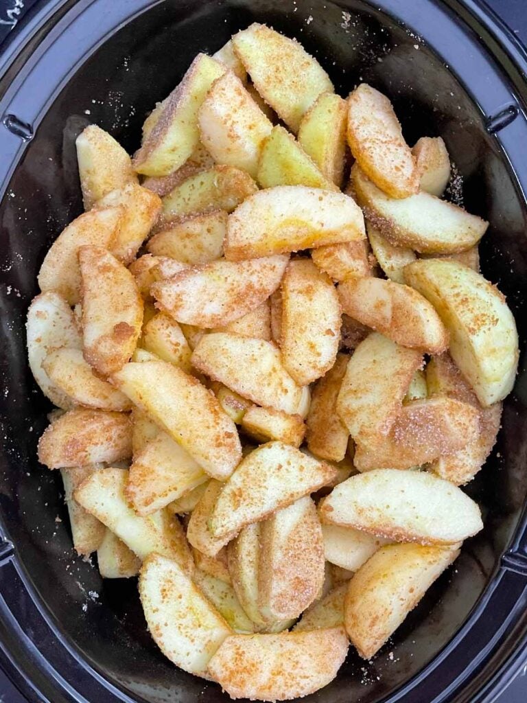 Peeled and sliced apples tossed with sugar and warm spices in a slow cooker.