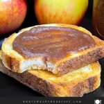 Slow cooker apple butter in a mason jar and smeared on a piece of sourdough toast.